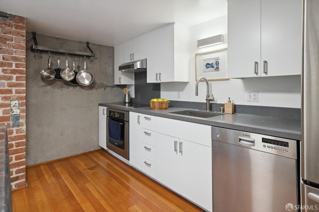 kitchen with white cabinetry, sink, light hardwood / wood-style flooring, and appliances with stainless steel finishes