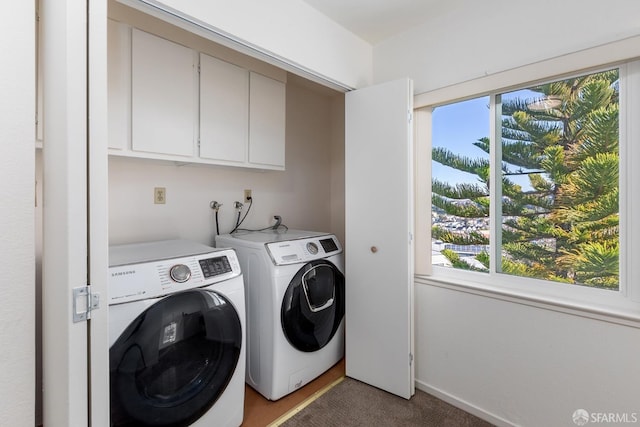 clothes washing area with cabinets, separate washer and dryer, and a wealth of natural light