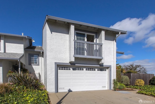 view of front of property featuring a balcony and a garage