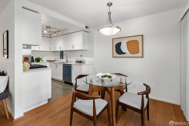 dining space with sink and hardwood / wood-style floors