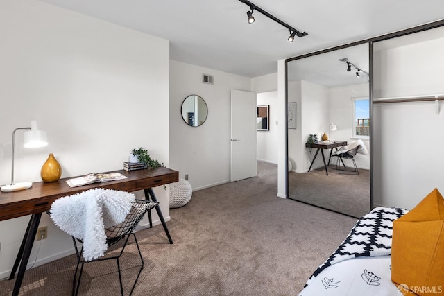 carpeted bedroom with rail lighting