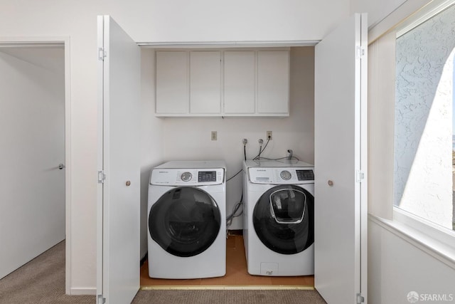 laundry room with cabinets, light carpet, and washer and clothes dryer