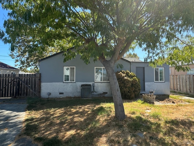 rear view of property with a lawn and central air condition unit