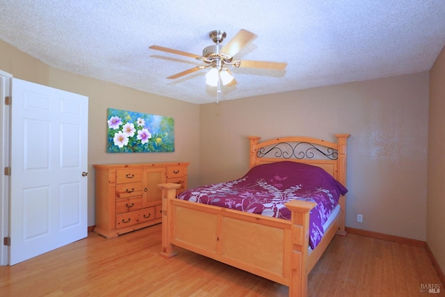 bedroom featuring light hardwood / wood-style flooring, a textured ceiling, and ceiling fan