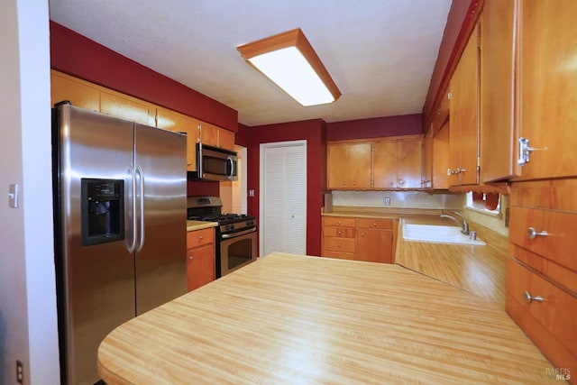 kitchen with appliances with stainless steel finishes, kitchen peninsula, and sink