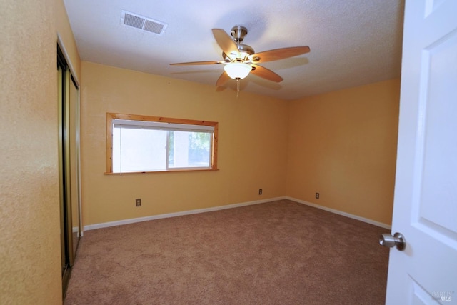 spare room featuring light carpet and ceiling fan