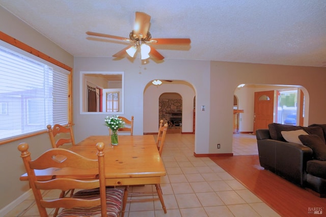 dining room with a textured ceiling, light tile patterned floors, and ceiling fan