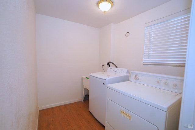 laundry room with light hardwood / wood-style flooring and separate washer and dryer