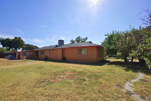 rear view of house featuring a yard