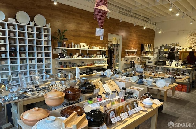 interior space with track lighting and wood walls