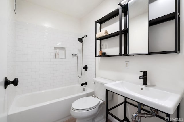 full bathroom featuring toilet, tiled shower / bath, and sink