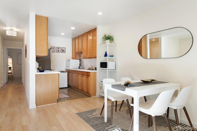 kitchen featuring sink, stainless steel refrigerator, and light hardwood / wood-style flooring