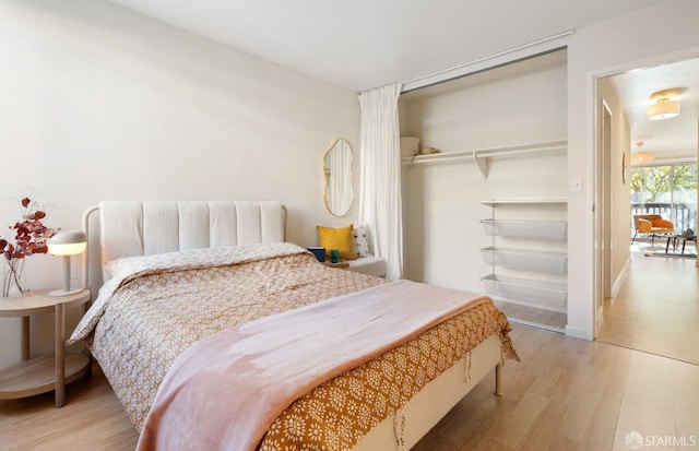 bedroom featuring wood-type flooring and a closet