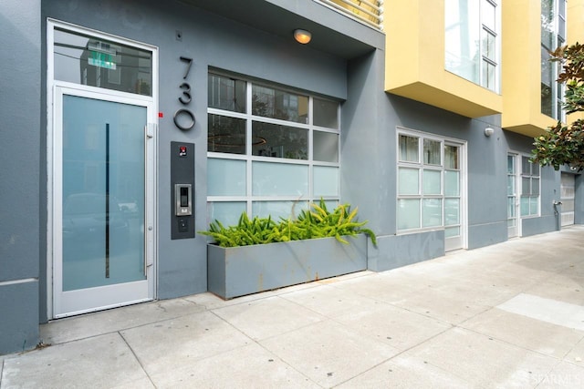 doorway to property featuring stucco siding