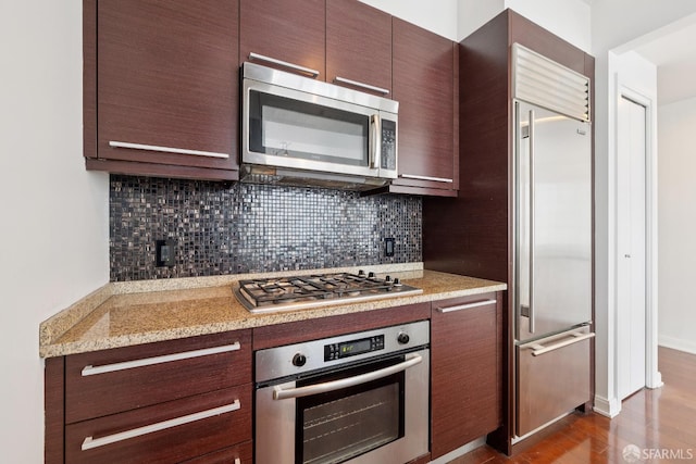 425 1st St Unit 1307, San Francisco, CA 94105 - kitchen featuring appliances with stainless steel finishes, backsplash, dark brown cabinets, and dark wood finished floors