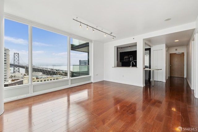 425 1st St Unit 1307, San Francisco, CA 94105 - unfurnished living room with a sink, track lighting, wood finished floors, a water view, and baseboards