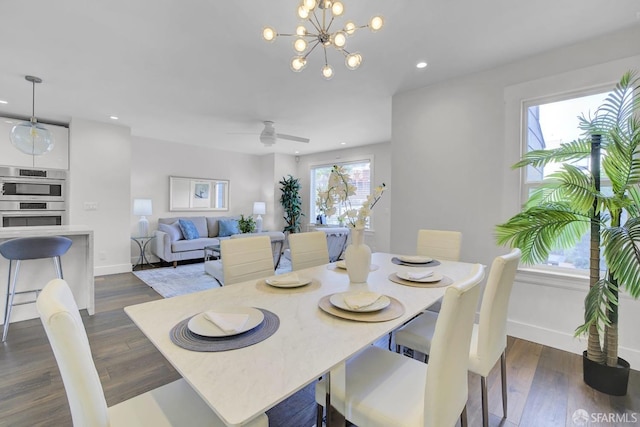 dining area featuring plenty of natural light, dark wood-type flooring, and ceiling fan with notable chandelier