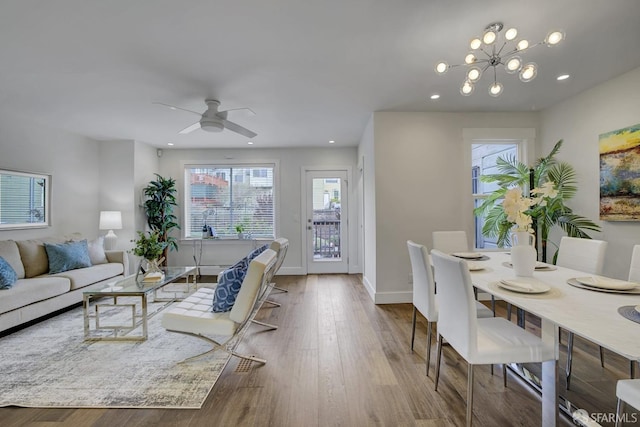 living room featuring light hardwood / wood-style floors and ceiling fan with notable chandelier