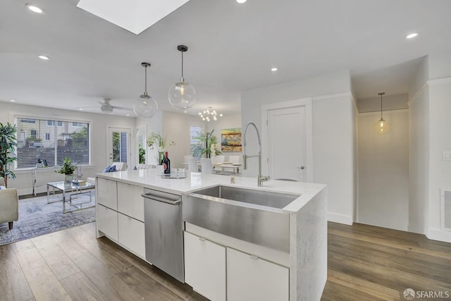 kitchen featuring white cabinetry, an island with sink, stainless steel dishwasher, and decorative light fixtures