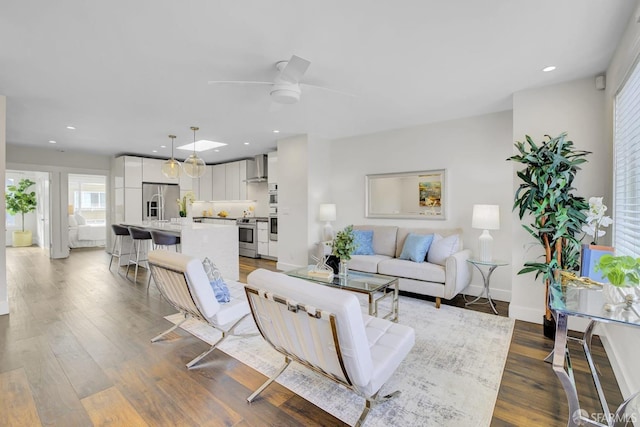 living room with ceiling fan and hardwood / wood-style floors