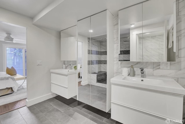 bathroom with a tile shower, vanity, tile patterned floors, and ceiling fan