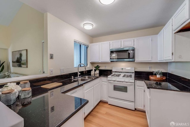 3685 Nutwood Ter Unit 313, Fremont, CA 94536 - kitchen featuring white appliances, a sink, white cabinets, light wood-type flooring, and a peninsula