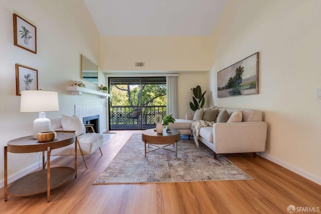 3685 Nutwood Ter Unit 313, Fremont, CA 94536 - living room with wood finished floors, a high ceiling, a tiled fireplace, and baseboards