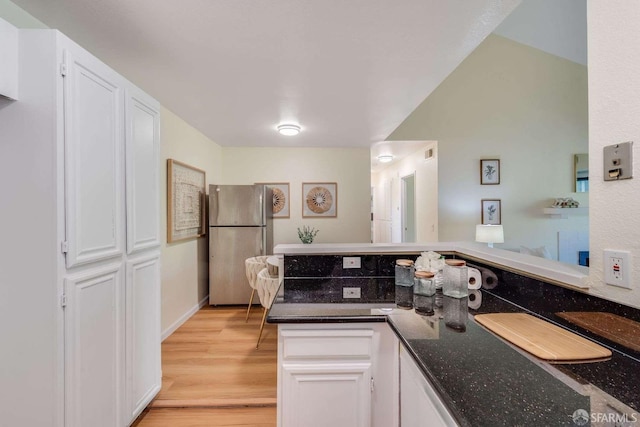 3685 Nutwood Ter Unit 313, Fremont, CA 94536 - kitchen with freestanding refrigerator, white cabinetry, light wood-style flooring, and dark stone counters