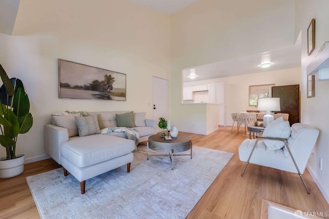 3685 Nutwood Ter Unit 313, Fremont, CA 94536 - living room featuring light wood-style flooring, a towering ceiling, and baseboards