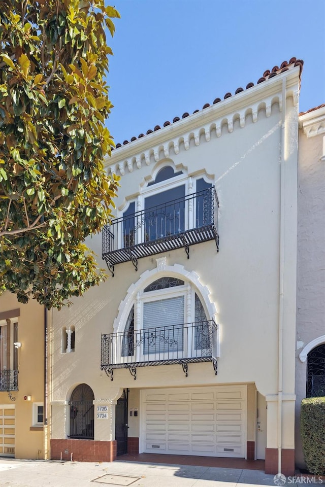 view of front facade with a garage and a balcony