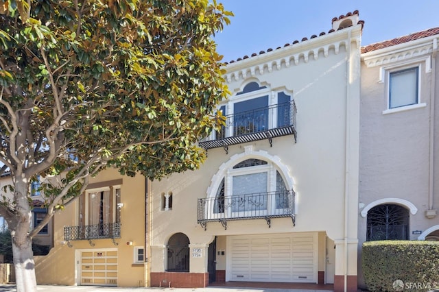 mediterranean / spanish home featuring a garage and a balcony