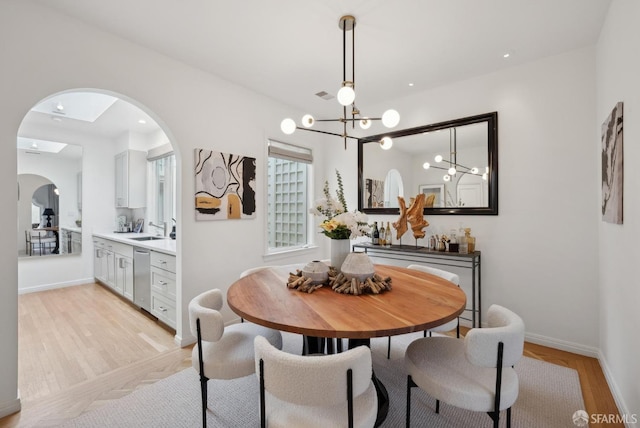 dining area with sink and light wood-type flooring