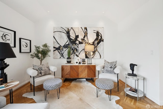 sitting room featuring parquet flooring and vaulted ceiling