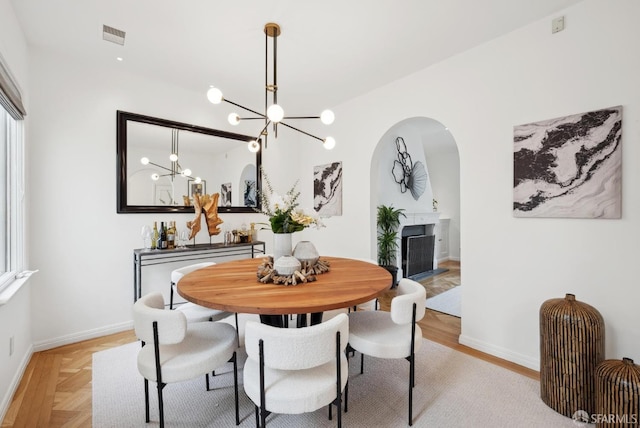 dining space featuring light parquet floors and a notable chandelier