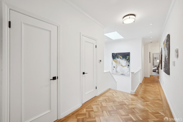 hallway featuring crown molding, a skylight, and light parquet floors