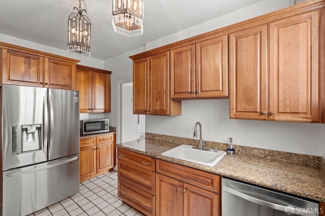 kitchen featuring brown cabinetry, appliances with stainless steel finishes, and a sink