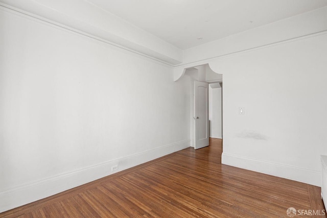 unfurnished room with baseboards and wood finished floors