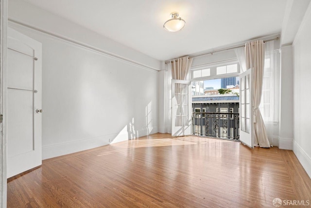 unfurnished living room featuring wood finished floors and baseboards