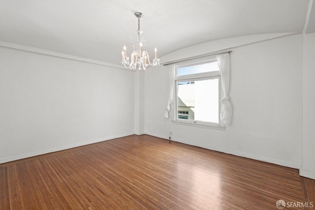 unfurnished room featuring vaulted ceiling, an inviting chandelier, baseboards, and wood finished floors