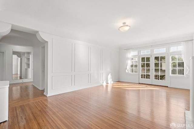 spare room featuring a decorative wall and wood finished floors