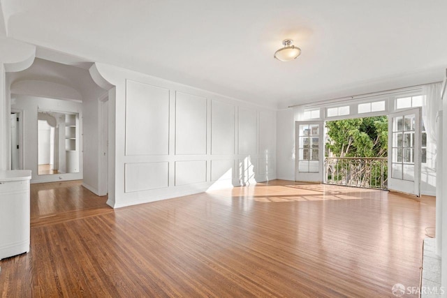 spare room with a decorative wall and wood finished floors