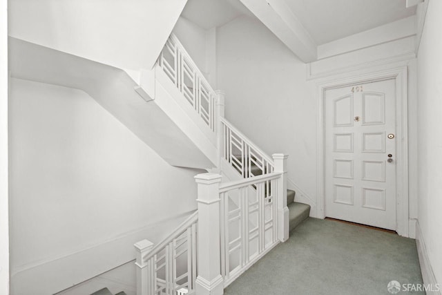 hallway with stairway and light carpet