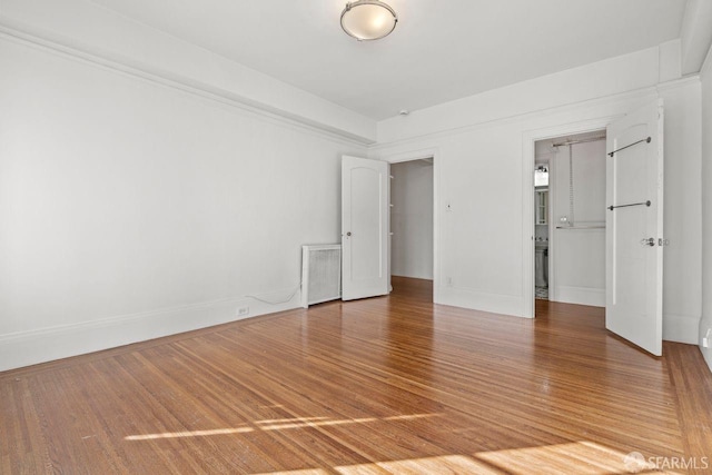 empty room with light wood-type flooring and baseboards