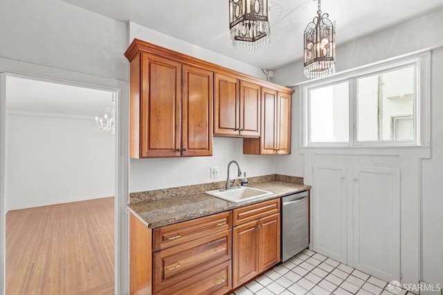 kitchen featuring a chandelier, pendant lighting, brown cabinets, stainless steel dishwasher, and a sink