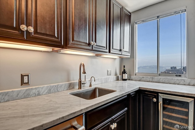 kitchen with wine cooler, dark brown cabinets, and sink