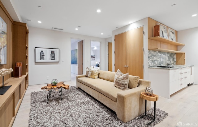 living room featuring sink and light wood-type flooring