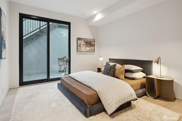 bedroom featuring access to exterior and light hardwood / wood-style flooring