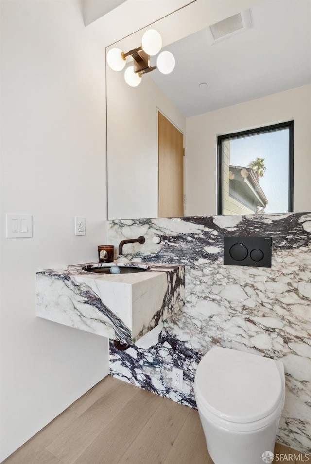 bathroom featuring vanity, wood-type flooring, tile walls, and toilet