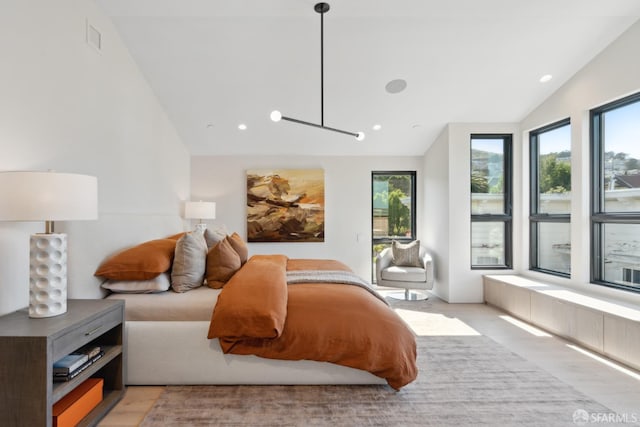 bedroom with vaulted ceiling and light wood-type flooring