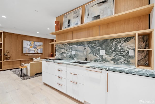 kitchen featuring tasteful backsplash, gas stovetop, sink, stone countertops, and white cabinets